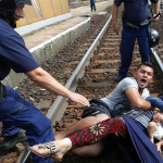 .یک خانواده سوری در حال عبور از مرز برای شکستن محاصره پلیس خود را روی ریل قطار انداخته اند
